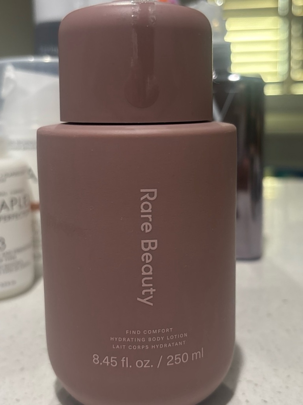 Rare Beauty hydrating body lotion in dusty mauve
